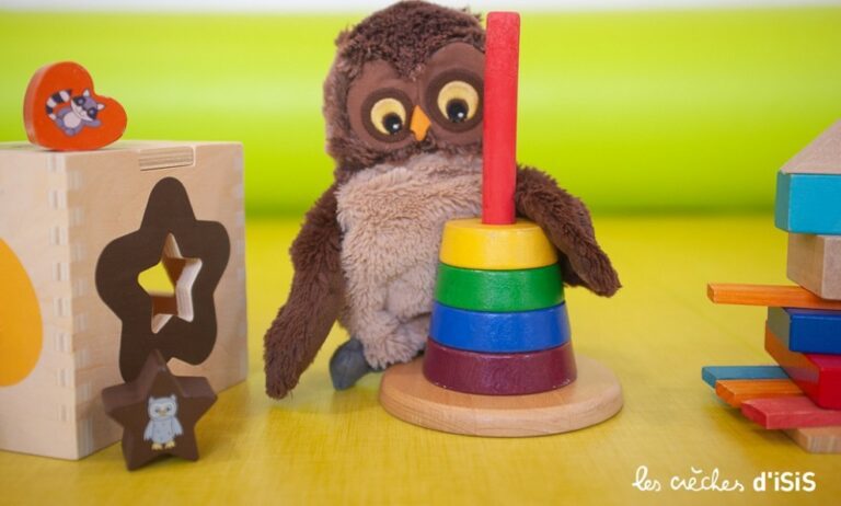 Un hibou en peluche avec des jouet pour enfant en bois de la micro-crèche Strasbourg Neudorf